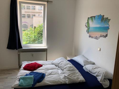 a bed in a bedroom with a window at Ruhige Wohnung bei der Burg im OG1 in Kröllwitz