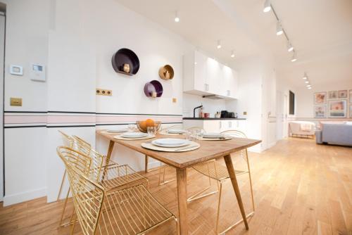 a kitchen and dining room with a wooden table and chairs at Dreamyflat - Charonne in Paris