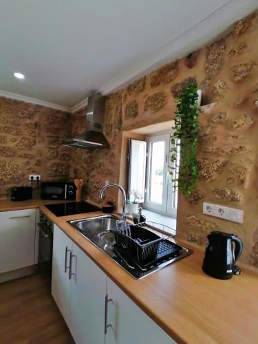 a kitchen counter with a sink and a window at Cantinho D'Aldeia in Guarda