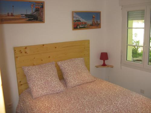 a bedroom with a bed with two pillows and a window at Chambre d'hôtes Chez Karine et Roland in Le Fied