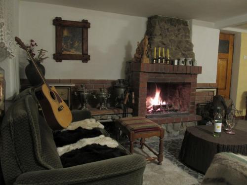 a living room with a guitar and a fireplace at Chata za Górami in Zagórze Śląskie