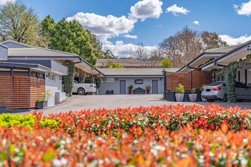 a house with a lot of flowers in a driveway at Cotswold Gardens in Armidale