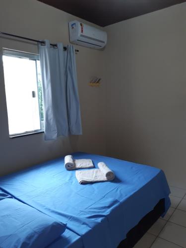 Un dormitorio con una cama azul con toallas. en Casa da Família Carvalho - 986, en Belém