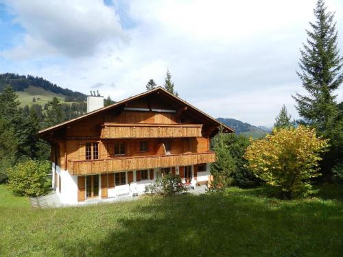 a wooden house on a hill in a field at Apartment Zapfe - Küenzi by Interhome in Saanenmöser