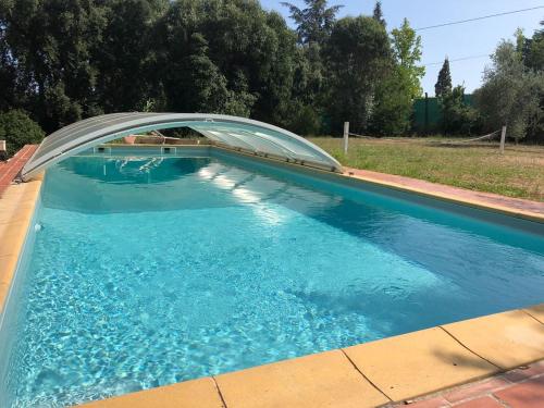 a swimming pool with a bridge over it at L'Oliveraie in La Londe-les-Maures