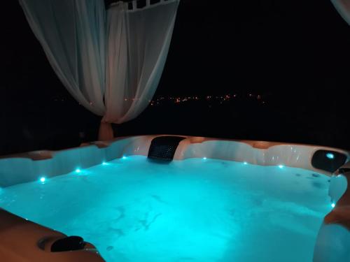 a bath tub with a view of a city at night at Small Hill Heaven in Varaždin Breg