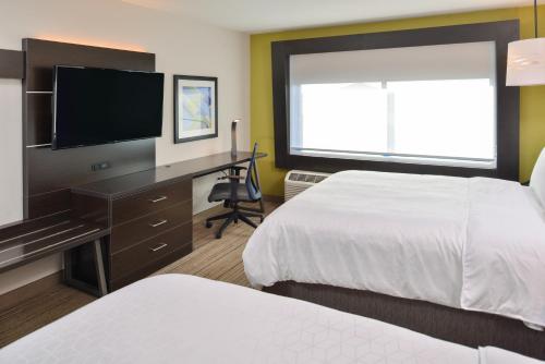 a hotel room with two beds and a flat screen tv at Holiday Inn Express & Suites - Olathe West by IHG in Olathe