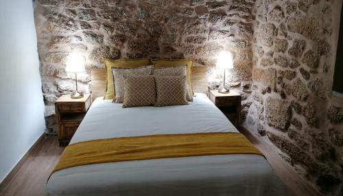 - une chambre avec un grand lit et 2 lampes sur les tables dans l'établissement Cantinho D'Aldeia, à Guarda