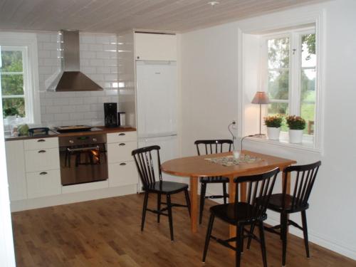 uma cozinha com uma mesa e cadeiras numa cozinha em Stuga Linnebråten em Värnamo