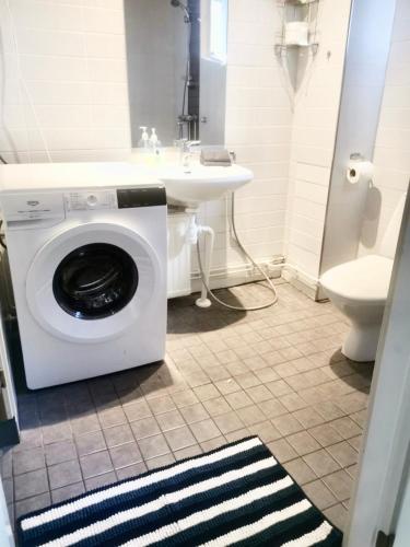 uma casa de banho com uma máquina de lavar roupa e um lavatório em Kuusamon Helmi, Sauna, Parveke, Terassi em Kuusamo