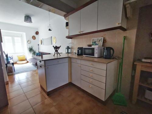 een keuken met witte kasten en een magnetron op een aanrecht bij Sintra Central Flat in Sintra