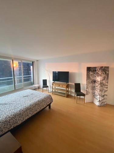 1 dormitorio con 1 cama, 2 sillas y escritorio en Appartement La Défense The View en Puteaux