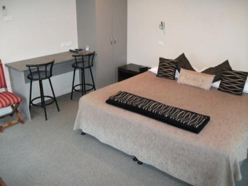 um quarto com uma cama grande e um balcão em Scenicland Motels em Greymouth