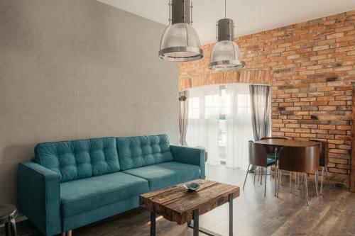 uma sala de estar com um sofá azul e uma parede de tijolos em Old Town Mieszczanska - heart of Wroclaw em Breslávia