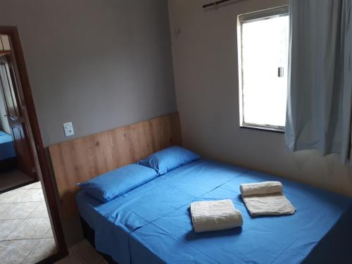 um quarto com uma cama azul com duas toalhas em Casa da Família Carvalho - 986 em Belém