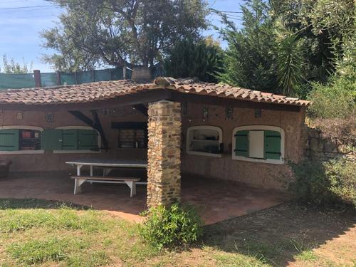 a small house with a bench in front of it at L'Oliveraie in La Londe-les-Maures