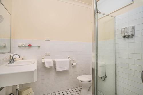 a bathroom with a toilet and a sink and a shower at Cotswold Gardens in Armidale