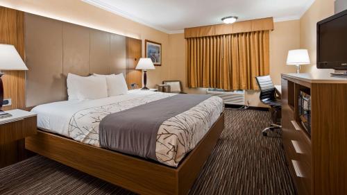 a hotel room with a bed and a flat screen tv at Best Western Airpark Hotel - Los Angeles LAX Airport in Inglewood