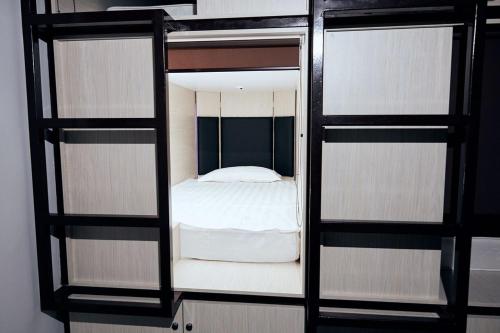 1 dormitorio con 1 cama en una habitación con espejo en Hotel Kapsula en Astaná