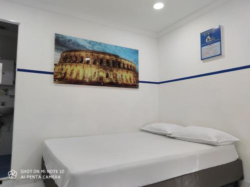 a bed in a room with a painting on the wall at Casa Hotel Manco Mora in Medellín