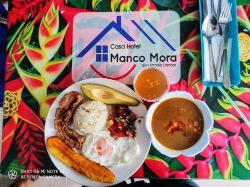 einen Teller Essen mit einem Hot Dog und einer Schüssel Suppe in der Unterkunft Casa Hotel Manco Mora in Medellín