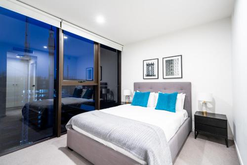 a bedroom with a large bed and a large window at Opera Apartments South Brisbane in Brisbane