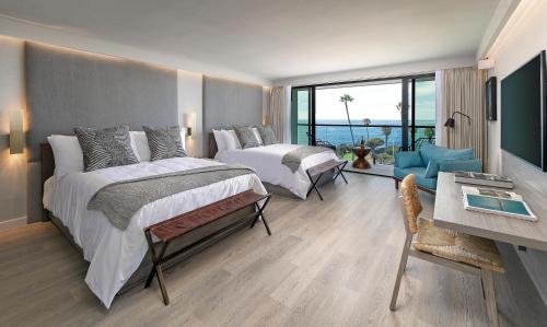 La Jolla Cove Suites في سان دييغو: غرفة فندقية بسريرين ومكتب وإطلالة