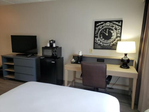 a hotel room with a desk with a bed and a television at Country Inn & Suites by Radisson, Buford at Mall of Georgia, GA in Buford