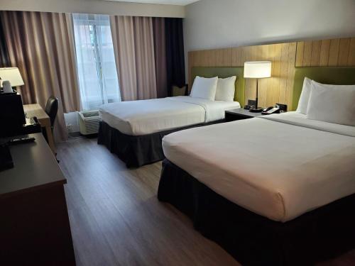 a hotel room with two beds and a desk with lamps at Country Inn & Suites by Radisson, Buford at Mall of Georgia, GA in Buford