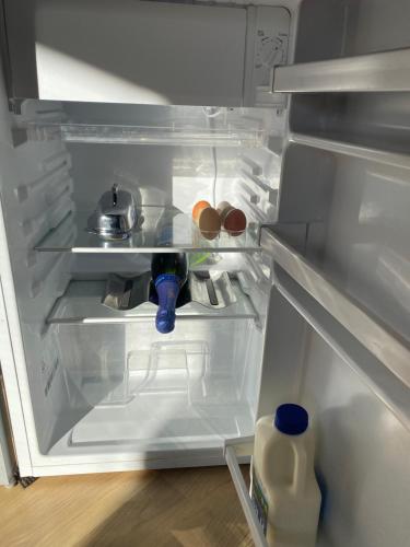 an open refrigerator with a bottle of milk in it at Ionaforest Yurt in Wingello