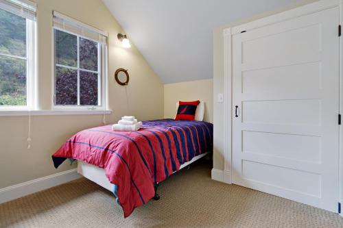 a bedroom with a bed with a red blanket and a window at 3 Bed 3 Bath Vacation home in Eastsound in Eastsound