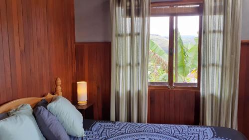 オロシにあるMontaña Linda Guest House Orosiのベッドと景色の見える窓のある寝室
