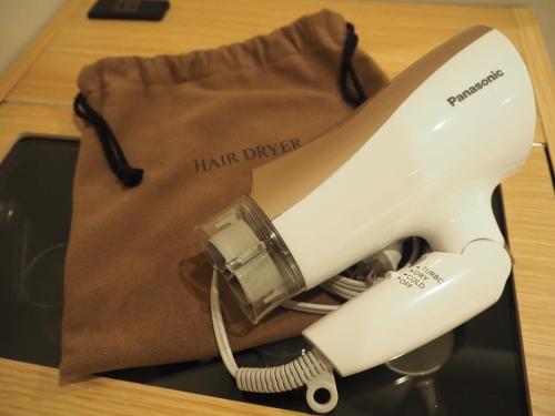a white hair dryer sitting on top of a bag at Compass Hotel Nagoya in Nagoya