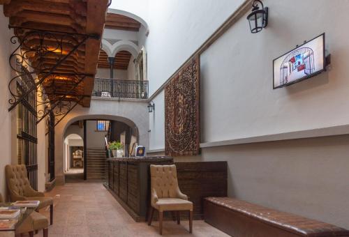 einen Flur mit Stühlen und eine Bar in einem Gebäude in der Unterkunft Hotel Madero in Querétaro
