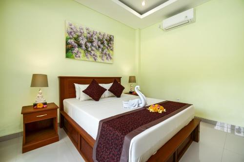 Hidden Padma Retreat في أوبود: غرفة نوم بسرير ودهان على الحائط
