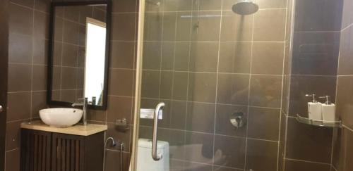 uma casa de banho com um chuveiro, um lavatório e um WC. em Gold Coast Rose Studio em Banting