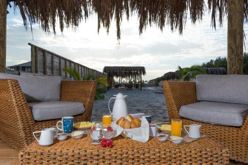 a table with food and drinks on a patio at ALAS Y ARENA in Vichayito