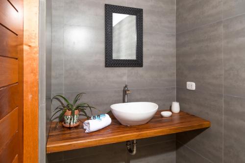 a bathroom with a white bowl sink on a wooden counter at ALAS Y ARENA in Vichayito