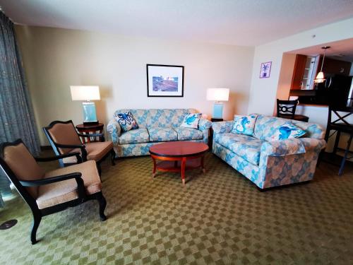 sala de estar con sofá, mesa y sillas en Deluxe Ocean Front Two-Bedroom Condo in Sandy Beach Resort en Myrtle Beach