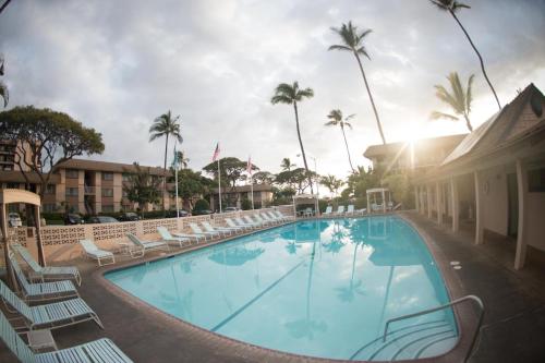 uma piscina num hotel com cadeiras e palmeiras em BeachFront Kihei Kai Nani - Maui Vista Deluxe Condos em Kihei