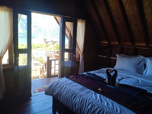 Un dormitorio con una cama con un gato. en Lakeside Log Cabins, en Kintamani
