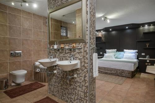 a bathroom with two sinks and a bed in a room at Ya Rona Sea View -5 Bedroom Ramsgate Holiday Home KRB1 in Margate