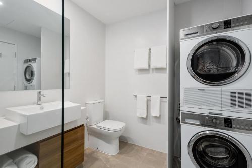 uma casa de banho com um WC e uma máquina de lavar e secar roupa em Quest Perth Ascot em Perth