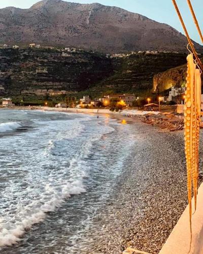 a view of a beach with a mountain in the background at Amphitrite's House in Neon Oitilon