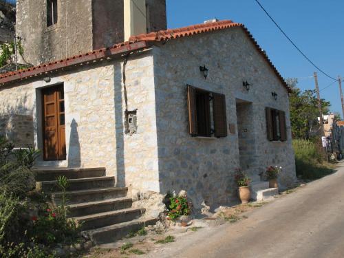 a small stone building with a door and stairs at Amphitrite's House in Neon Oitilon