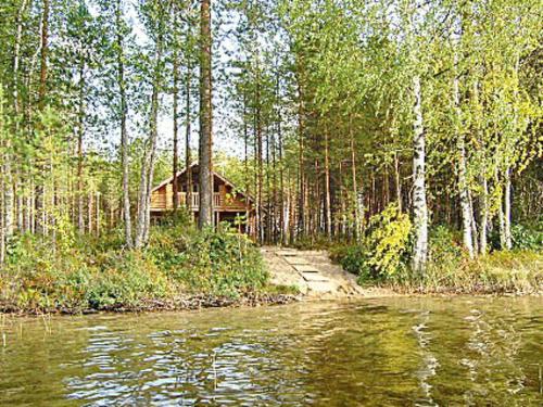 ein Blockhaus im Wald neben einem Fluss in der Unterkunft Holiday Home Hiekkaranta by Interhome in Saarikas