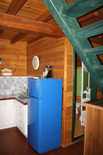a blue refrigerator in a kitchen with wooden walls at Villa Clementine in Piazza Armerina