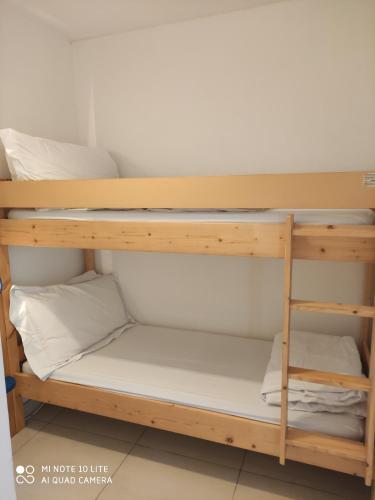 Residence Les Palmiers في نيس: سرير بطابقين في غرفة نوم مع وسائد بيضاء