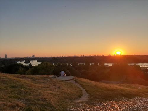 a sunset on a hill with a path at Apartments best city place in Belgrade
