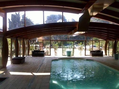 einen Pool in einem Haus mit einem großen Fenster in der Unterkunft Hotel SPA Plage St Jean in La Ciotat
